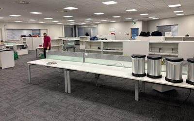 Open plan office being cleared, with desks and storage units emptied