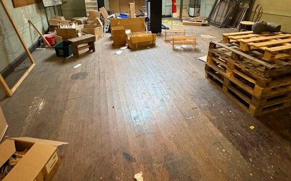 Empty shop unit with cardboard boxes and pallets to be cleared